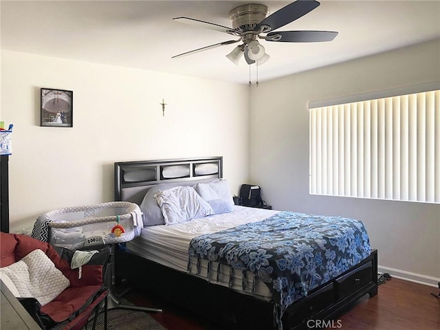 bedroom with wood finished floors, a ceiling fan, and baseboards