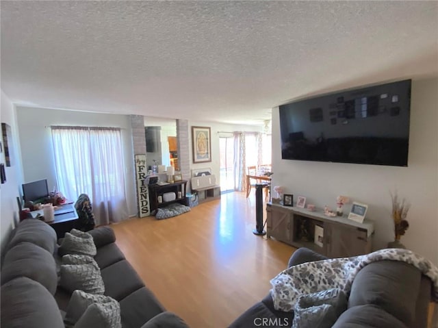 living area with a textured ceiling and wood finished floors