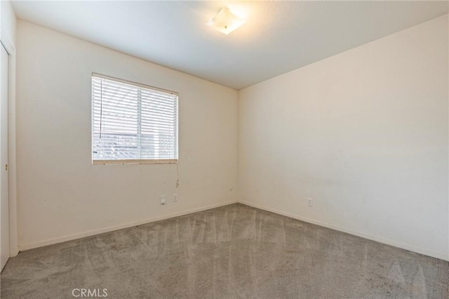 carpeted empty room with baseboards