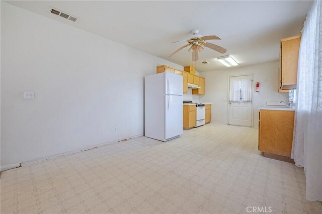 kitchen featuring light floors, light countertops, visible vents, white appliances, and under cabinet range hood