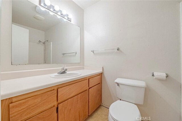 full bathroom with vanity, toilet, and walk in shower