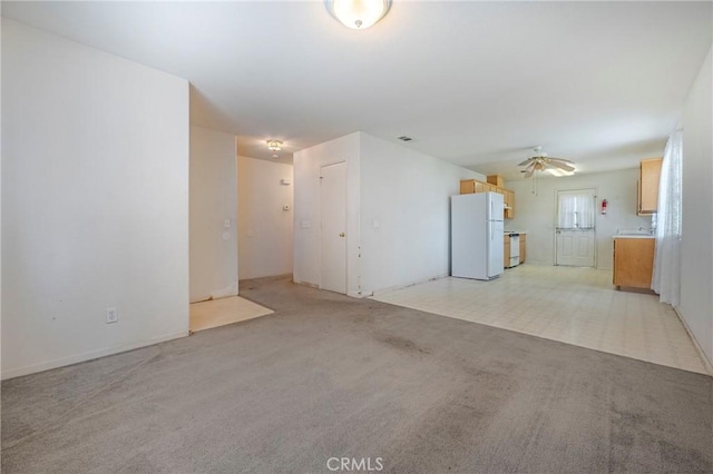 unfurnished living room featuring a ceiling fan and light colored carpet