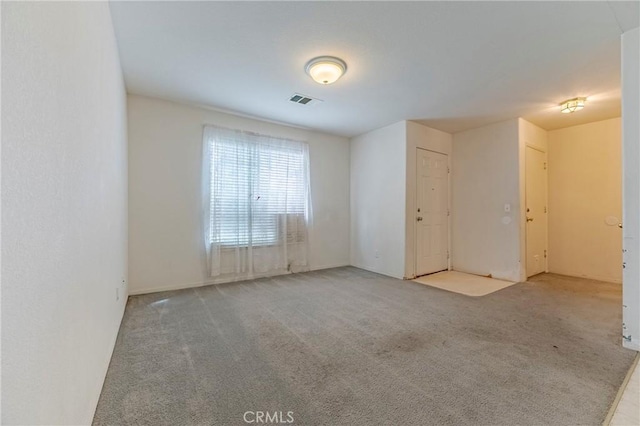 spare room featuring carpet and visible vents