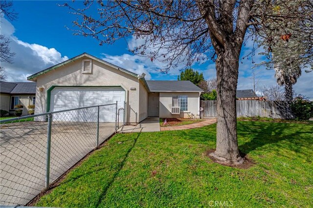 ranch-style house featuring an attached garage, fence, concrete driveway, stucco siding, and a front yard