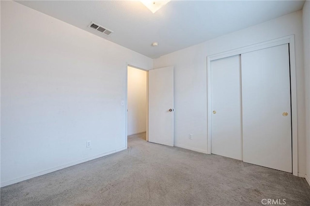 unfurnished bedroom featuring carpet, a closet, and visible vents