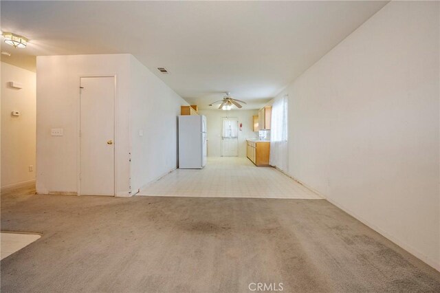 unfurnished room with ceiling fan, visible vents, and light colored carpet