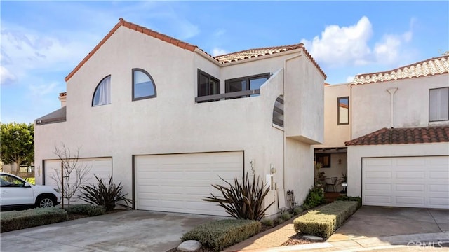 view of front of property with a tiled roof, stucco siding, and an attached garage