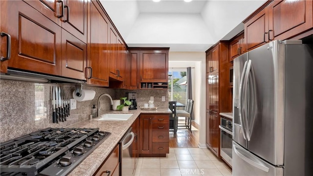kitchen featuring high vaulted ceiling, a sink, light tile patterned floors, stainless steel appliances, and backsplash