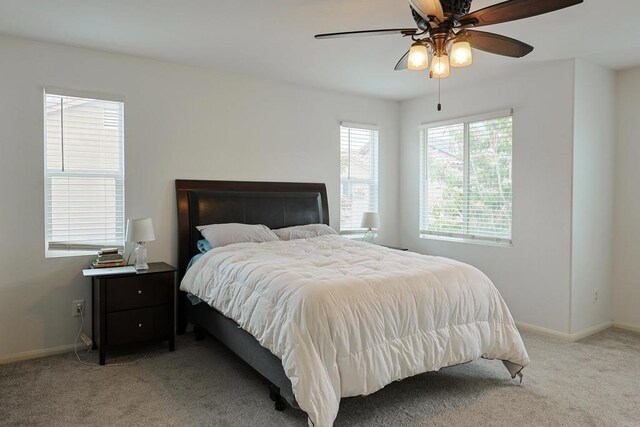 bedroom featuring baseboards, a ceiling fan, and light carpet