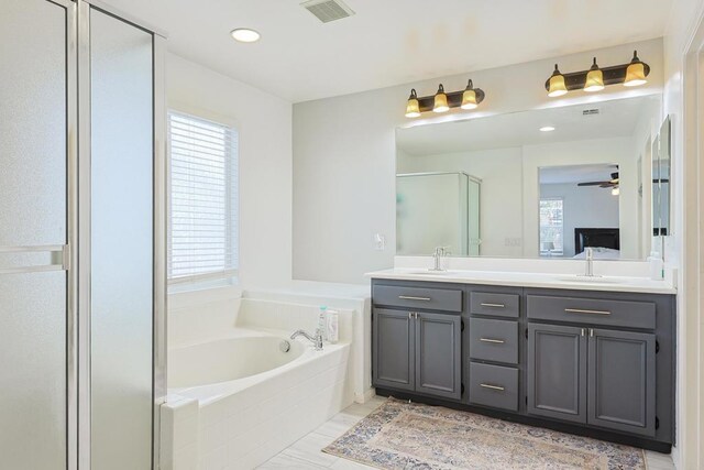 full bath featuring double vanity, a stall shower, a bath, visible vents, and a sink