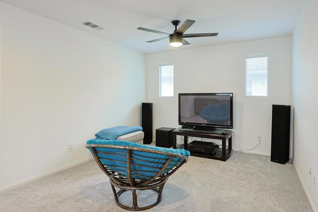 living area featuring visible vents, baseboards, a ceiling fan, and carpet