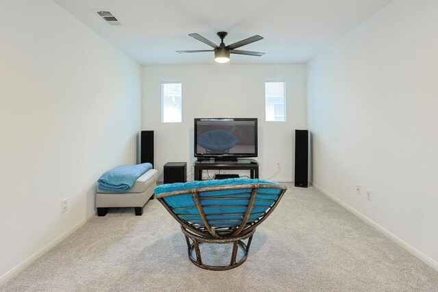 sitting room with a ceiling fan, a wealth of natural light, visible vents, and carpet floors