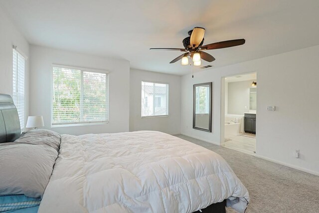 bedroom with visible vents, baseboards, ensuite bathroom, a ceiling fan, and light carpet