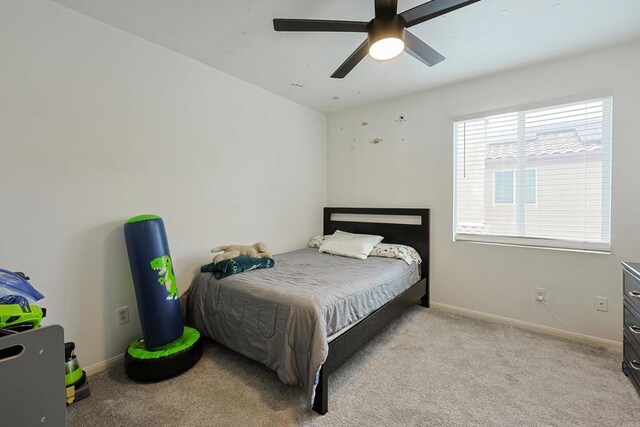 carpeted bedroom with baseboards and a ceiling fan