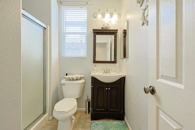 full bath with vanity, baseboards, tile patterned flooring, an enclosed shower, and toilet