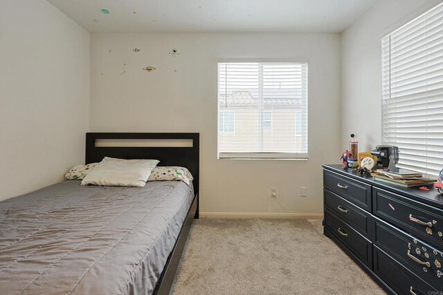 bedroom featuring baseboards and light carpet