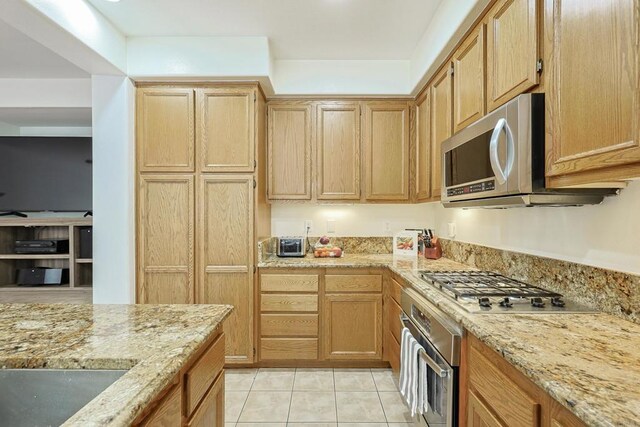 1582 Moonbeam Ln, Chula Vista, CA 91915 - kitchen with appliances with stainless steel finishes, light stone countertops, light tile patterned floors, and light brown cabinetry
