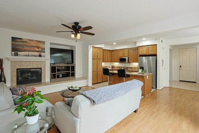 1582 Moonbeam Ln, Chula Vista, CA 91915 - living area with a ceiling fan, recessed lighting, light wood-style floors, a tile fireplace, and baseboards