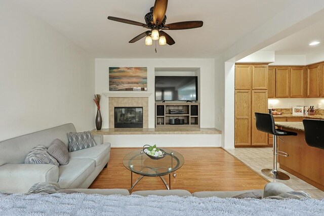 1582 Moonbeam Ln, Chula Vista, CA 91915 - living room featuring a ceiling fan, a tile fireplace, and light wood-style floors