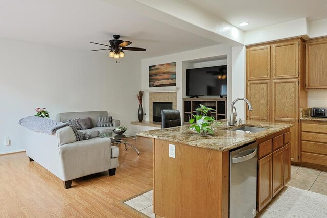 1582 Moonbeam Ln, Chula Vista, CA 91915 - kitchen featuring a sink, open floor plan, a fireplace, an island with sink, and light stone countertops