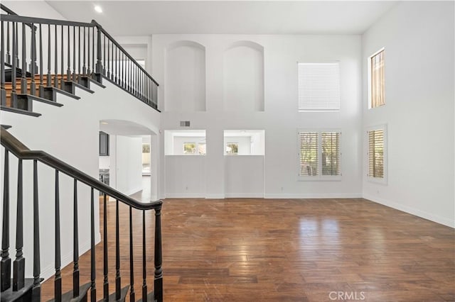 entryway featuring hardwood / wood-style flooring, visible vents, stairs, and baseboards