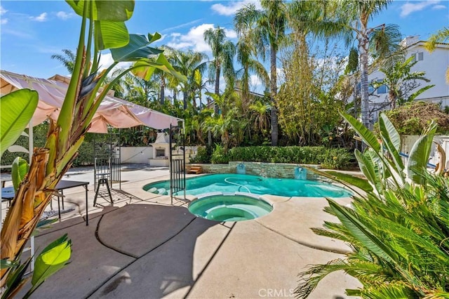 outdoor pool with an in ground hot tub, a patio, and a fenced backyard