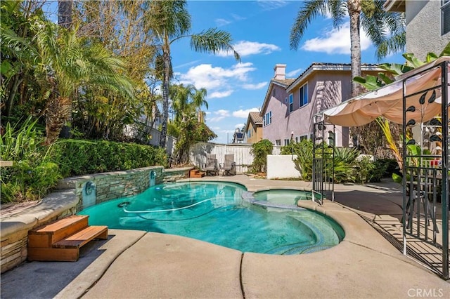 view of pool with a patio, a fenced backyard, and a pool with connected hot tub