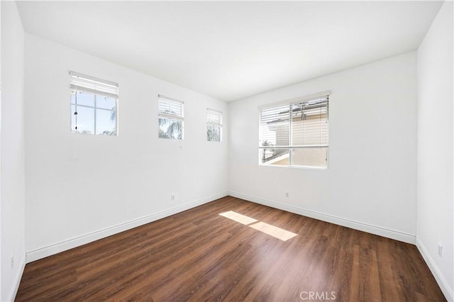 empty room featuring baseboards and wood finished floors