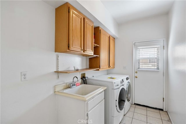 clothes washing area with light tile patterned floors, separate washer and dryer, a sink, and cabinet space