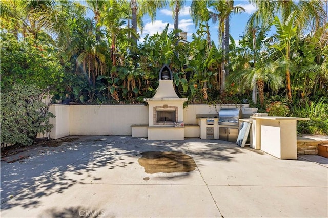 view of patio with exterior kitchen, area for grilling, and an outdoor fireplace