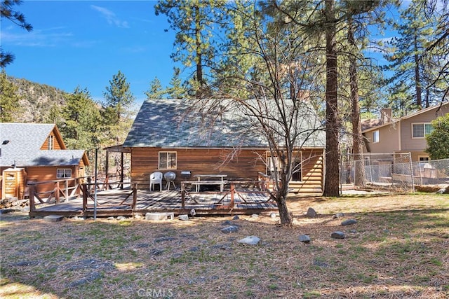 back of house featuring fence and a wooden deck