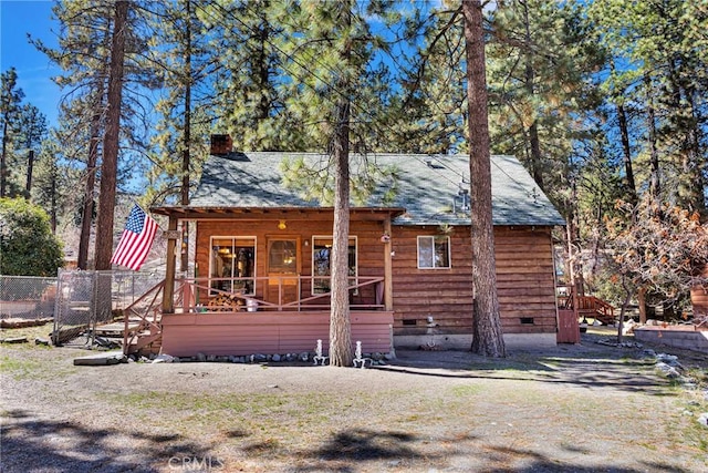 chalet / cabin featuring covered porch, crawl space, a chimney, and fence