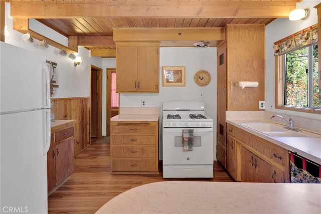 kitchen featuring light countertops, wood ceiling, a sink, white appliances, and beamed ceiling