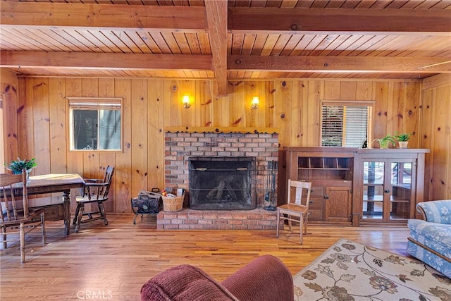 living room featuring a brick fireplace, wood ceiling, and wood finished floors