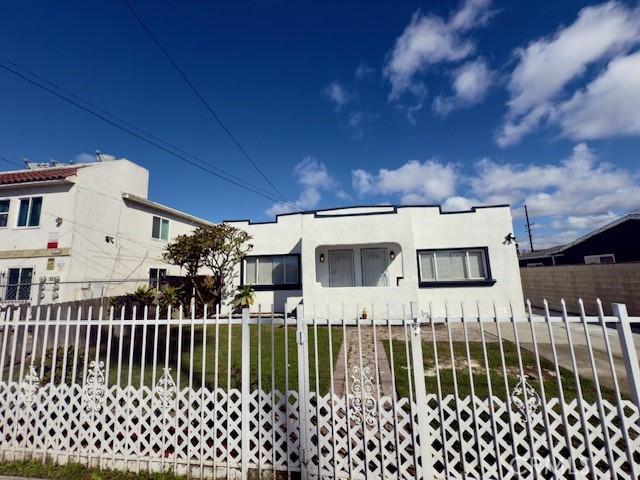 view of front facade with a fenced front yard and stucco siding