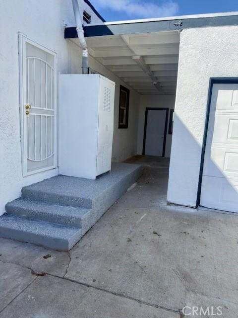 exterior space with a carport and stucco siding