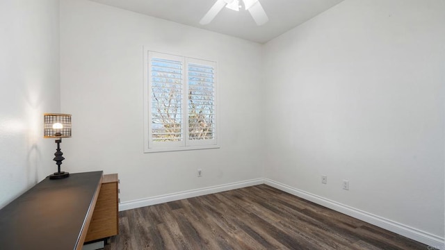 unfurnished office featuring dark wood-type flooring, ceiling fan, and baseboards