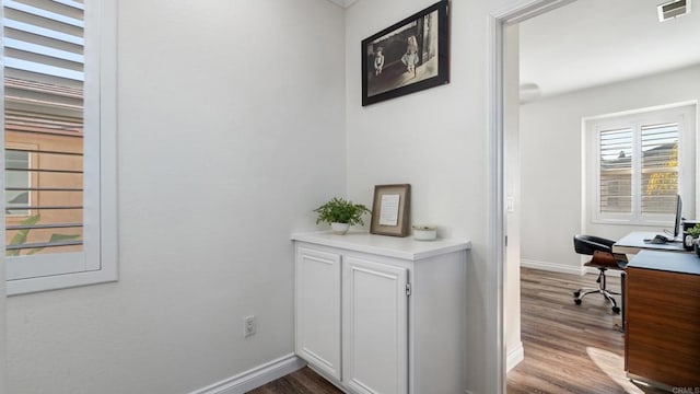 interior space with baseboards, visible vents, and dark wood finished floors