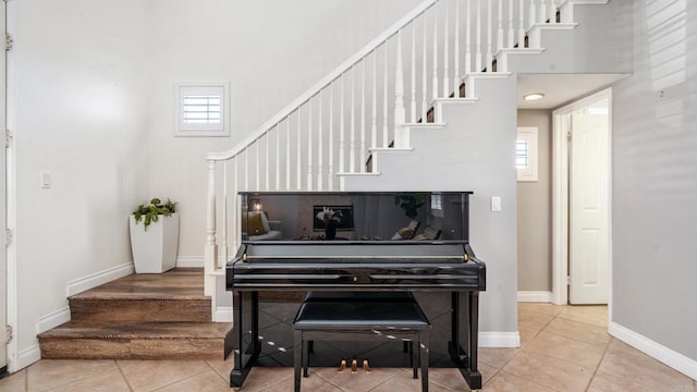 stairs featuring a high ceiling, baseboards, and tile patterned floors