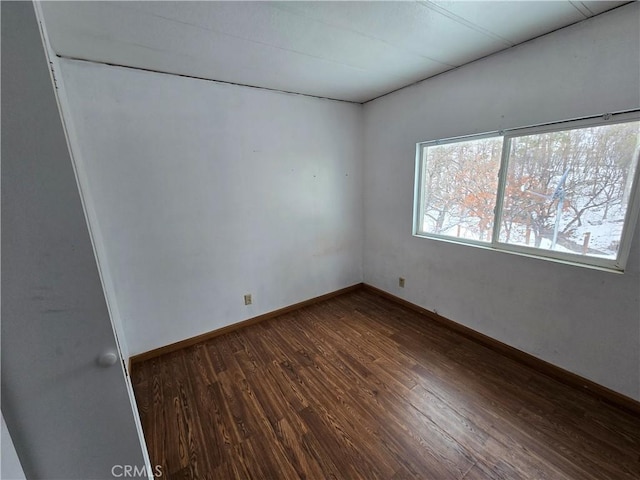 unfurnished room with dark wood-style floors and baseboards