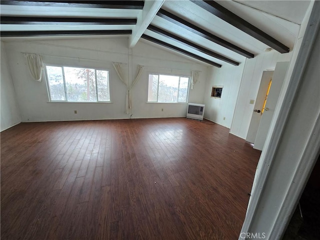 spare room featuring lofted ceiling with beams, heating unit, and dark wood-style floors