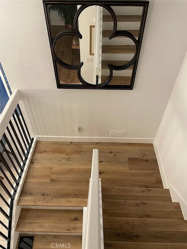 stairway featuring wood finished floors and baseboards