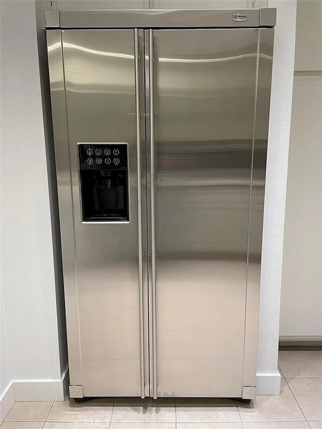 interior details with baseboards and stainless steel fridge