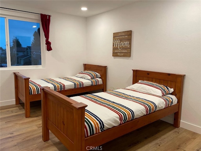 bedroom featuring light wood finished floors, recessed lighting, and baseboards