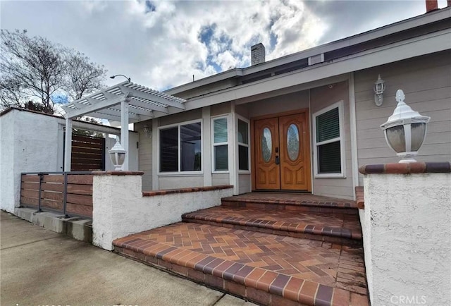 entrance to property with a pergola and a chimney