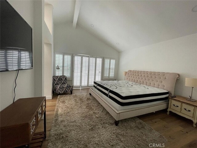 bedroom featuring beam ceiling, high vaulted ceiling, and wood finished floors