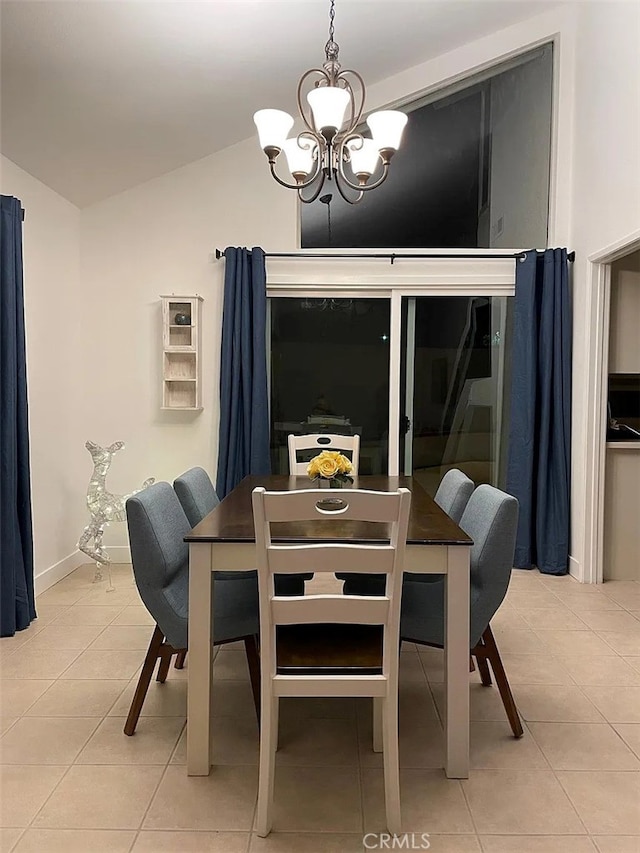 dining area featuring light tile patterned floors, baseboards, an inviting chandelier, and vaulted ceiling