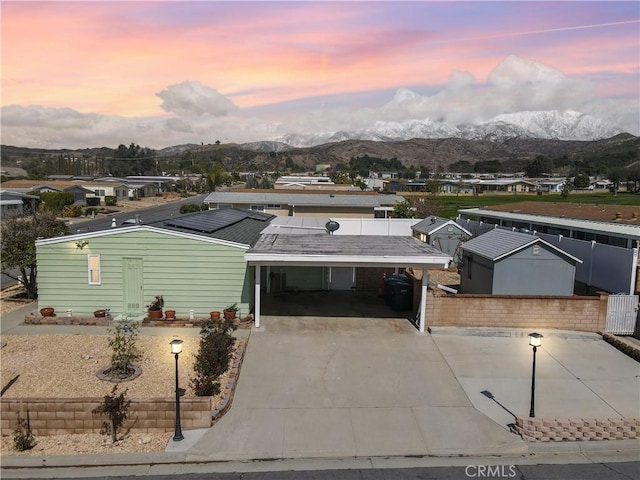 view of front of property with concrete driveway, a carport, and a mountain view