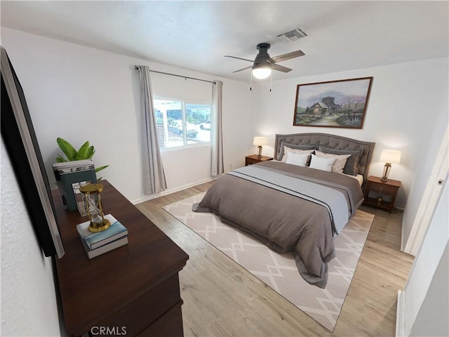 bedroom featuring visible vents, a ceiling fan, and light wood finished floors