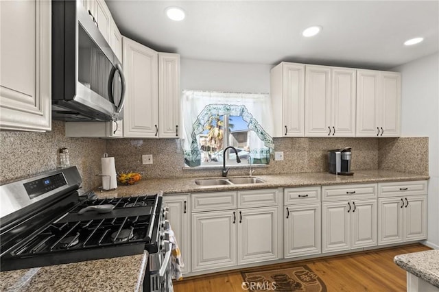 kitchen featuring white cabinets, stainless steel appliances, and a sink